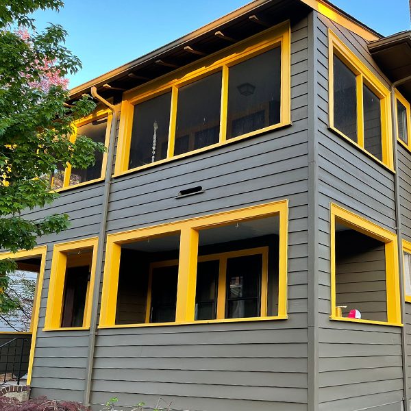Trimmings were painted a bright, sunshine yellow on the exterior of a 3 story house.